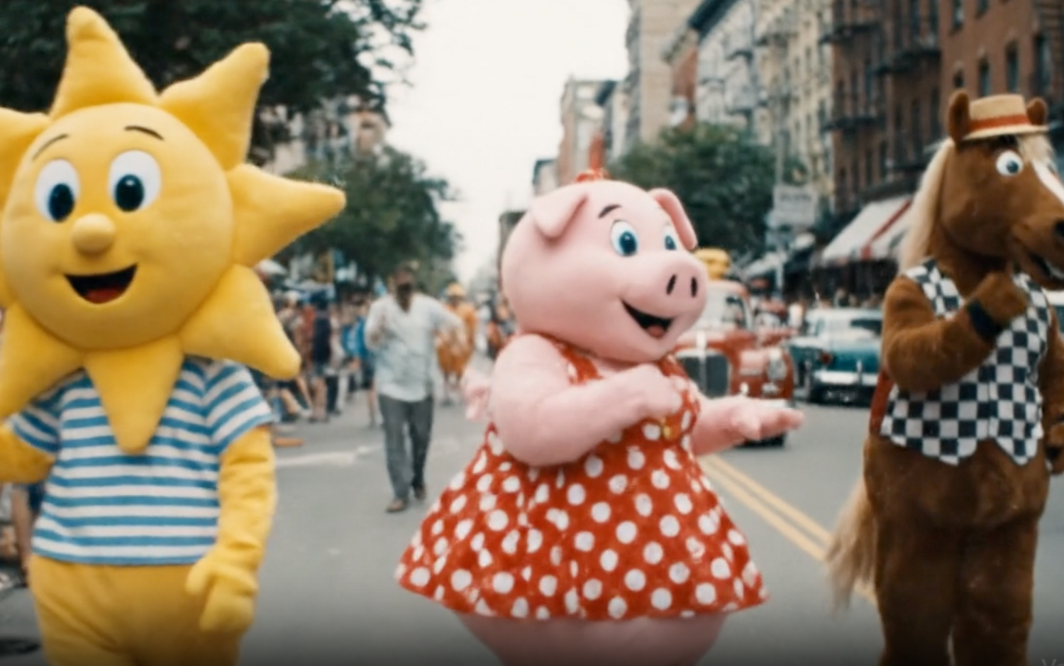 Sun, pig, and horse mascots on a city street with people around